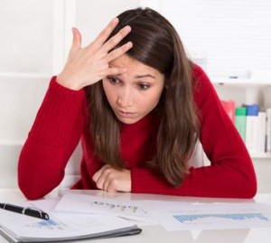 Junges Mädchen hat ein Blackout und schlägt sich beim Lernen an die Stirn