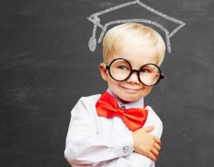 Kind steht vor Schultafel mit Doktorhut und Brille - Bildung und Bildungschancen