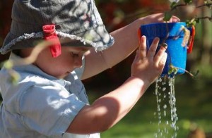 Kleinkind spielt mit Wasser in der Sonne Frühpädagogik Kleinkindpädagogik