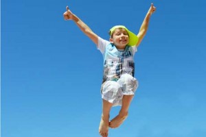 Glückliches Kind voller Selbstbewusstsein jubelt beim Hüpfen