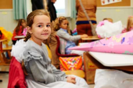 Erster Schultag Mädchen im Klassenzimmer mit Schultüte und Schulranzen